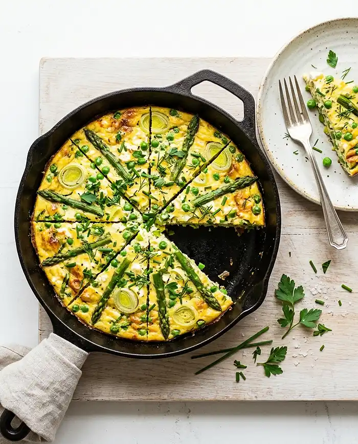 Frittata Recipes 2 Sliced spring vegetable frittata with asparagus, peas, and leeks in a skillet, shot from overhead one of the best Frittata Recipes