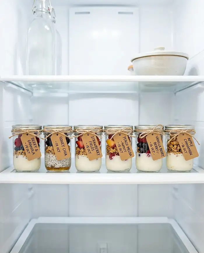 Healthy Breakfast Snacks 6 Row of meal-prepped Greek yogurt granola cups and berry parfaits stored in a refrigerator