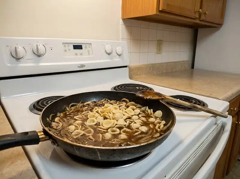 One-Pot French Onion Pasta 5 dry orecchiette cooking in still-thin broth, pieces pale and chalky in the middle, sauce not reduced