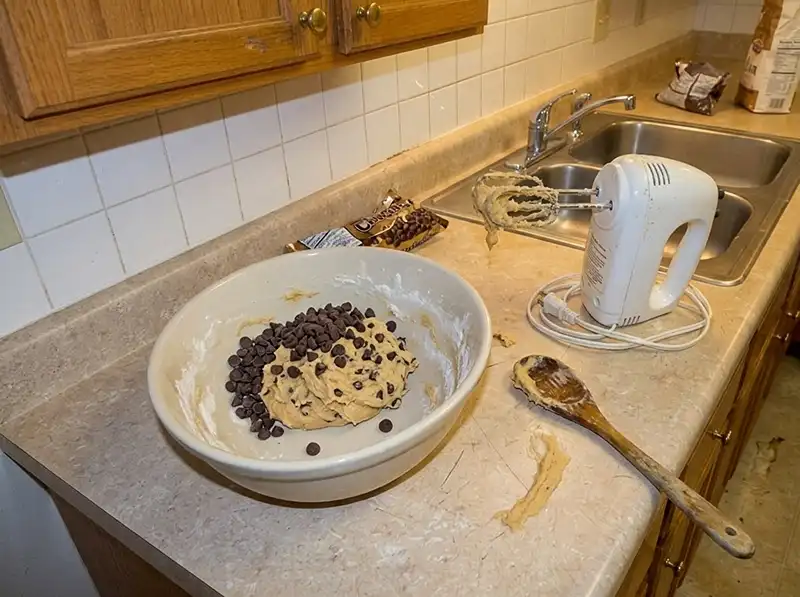 Nestle Toll House Cookie Recipe 4 soft dough half mixed in the large bowl, morsels just tipped in and still clumped, dry flour streaks, electric hand mixer beside it with dough on the beaters